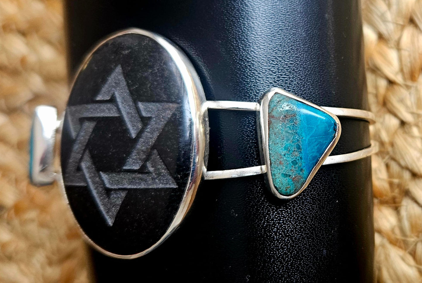 Sterling silver cuff bracelet with a 40x30mm black onyx cab, engraved with a star of David and 2 accent stones of Eilat stone from Israel, side 1 view