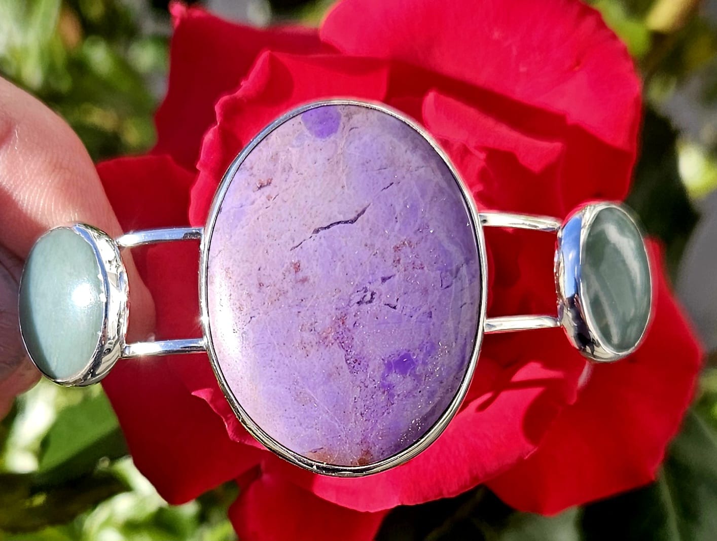 Sterling Silver Cuff bracelet with a 40x30mm cabochon of rare lavender Turkish nephrite jade, flanked by a pair of 18mm round cabochons of pale green Inanga Pounamu (nephrite jade) from New Zealand, all hand cut and set in sterling silver, top view.