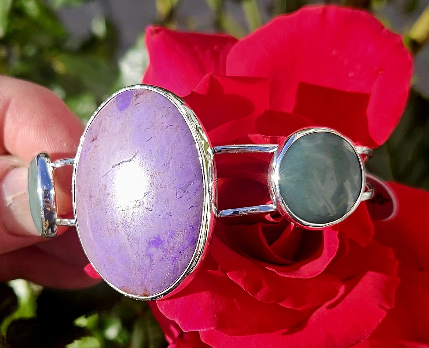 Sterling Silver Cuff bracelet with a 40x30mm cabochon of rare lavender Turkish nephrite jade, flanked by a pair of 18mm round cabochons of pale green Inanga Pounamu (nephrite jade) from New Zealand, all hand cut and set in sterling silver, angle showing flanking stone.
