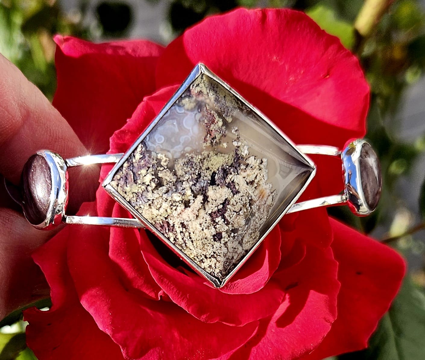 Sterling Silver Cuff bracelet with a 27x27mm square cabochon of Indonesian picture moss agate, flanked by a pair of purple New Zealand Aroha stones cut to 14mm round cabochons and set in sterling silver, top view.