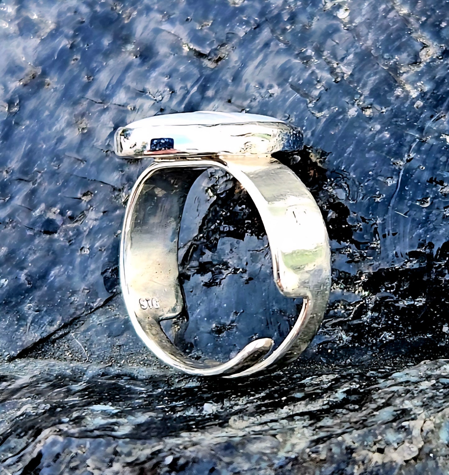 A beautiful 2.7ct Australian opal with lots of fire, hand cut and polished and set in a sterling silver, adjustable ring, side.