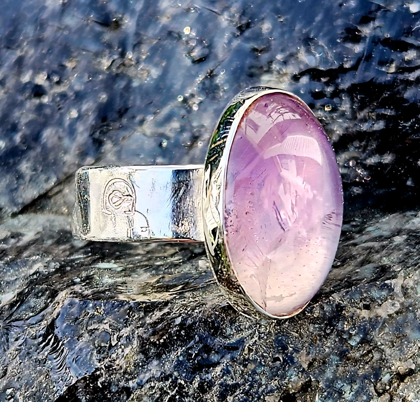 A soft purple amethyst, hand cut and polished to a 18x13mm cabochon and set in a sterling silver, adjustable ring, angle.