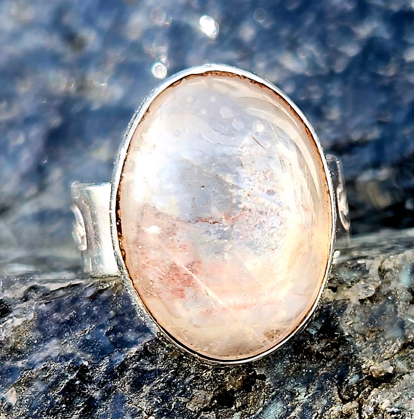 A sparkling clear quartz, hand cut and polished to a 18x13mm cabochon and set in a sterling silver, adjustable ring, top.