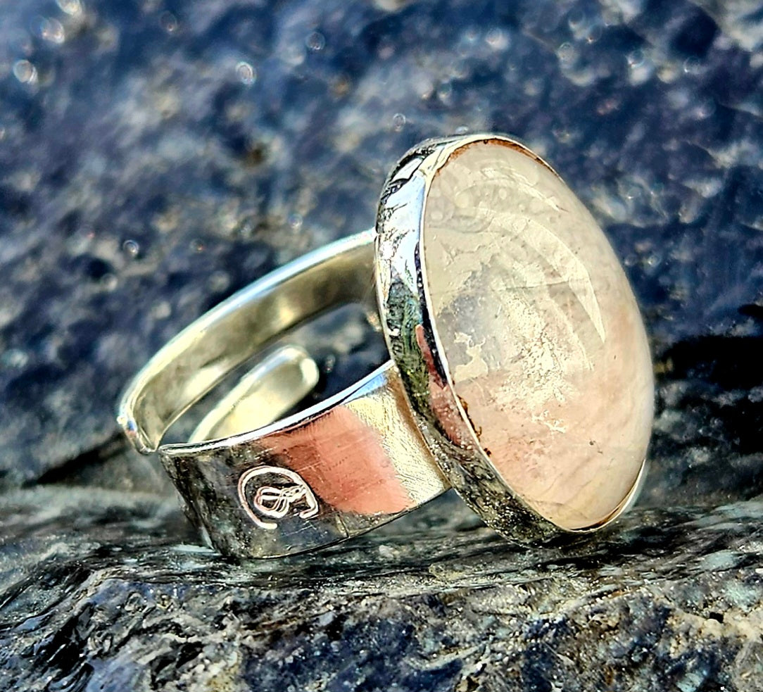 A sparkling clear quartz, hand cut and polished to a 18x13mm cabochon and set in a sterling silver, adjustable ring, angle.