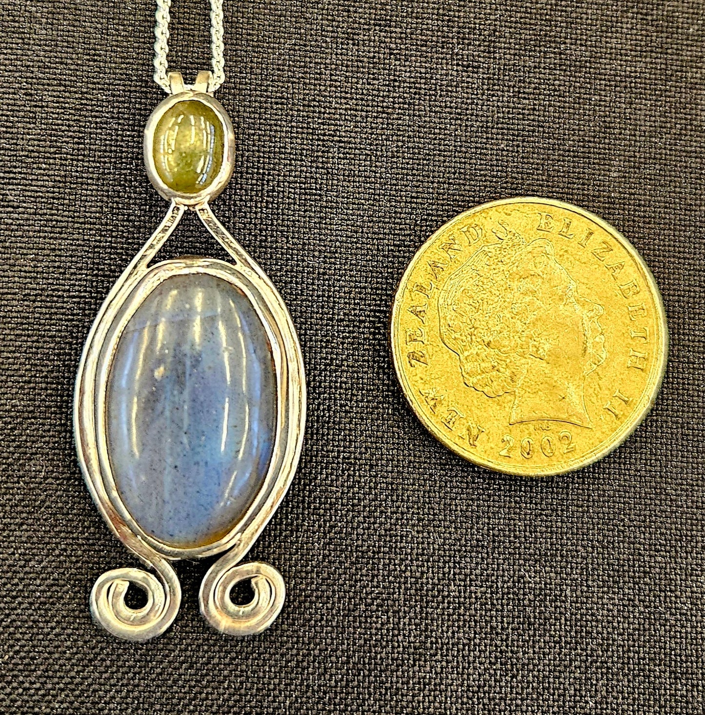 Radiant Labradorite pendant in sterling silver with glowing black star sapphire with a 18 inch sterling silver chain, with one dollar coin for size comparison