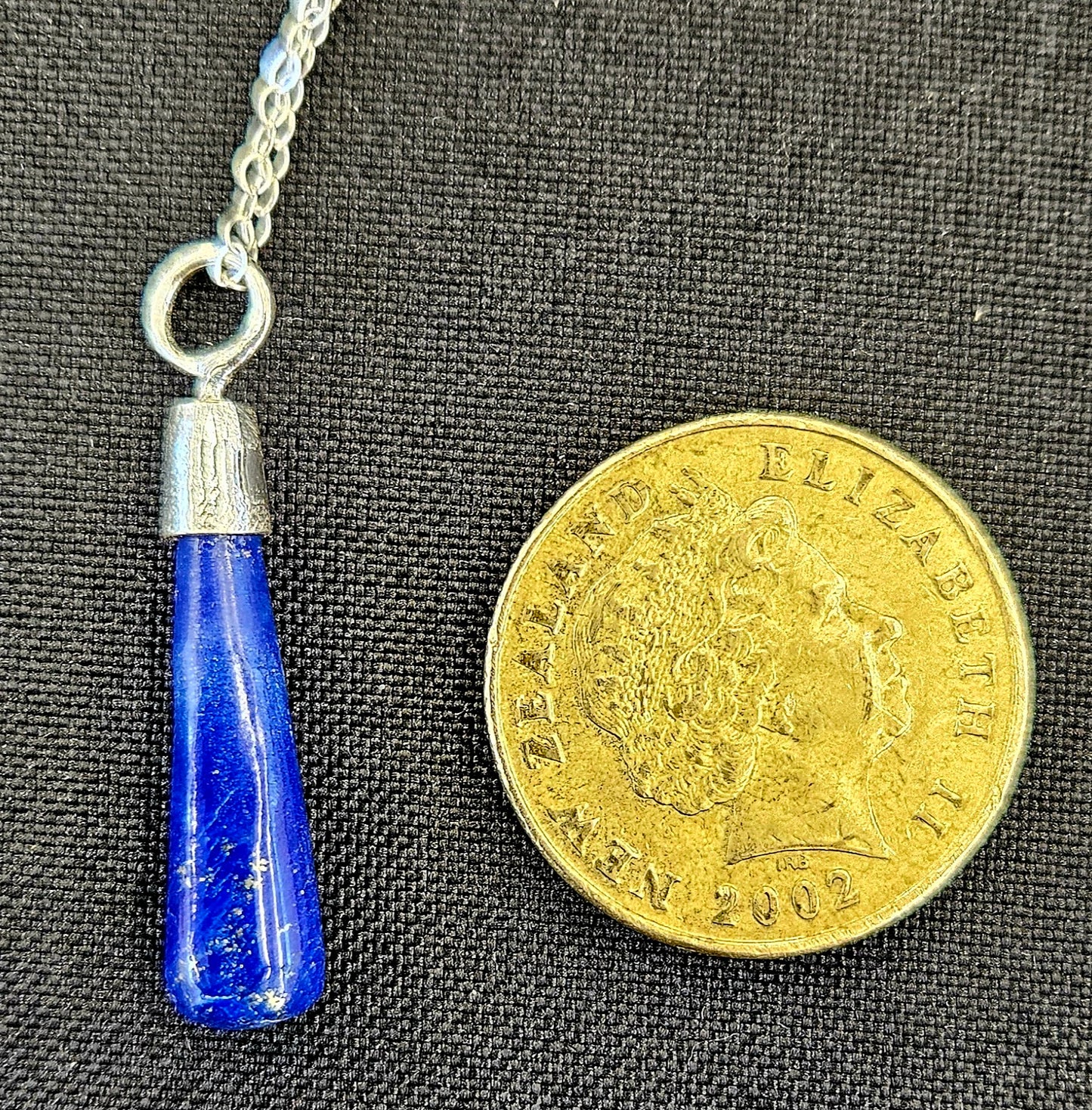 Lapis Lazuli pendulum with sterling silver setting, set to be worn as a necklace, so it's always handy, with a sterling silver chain with NZ one dollar coin for size comparison.