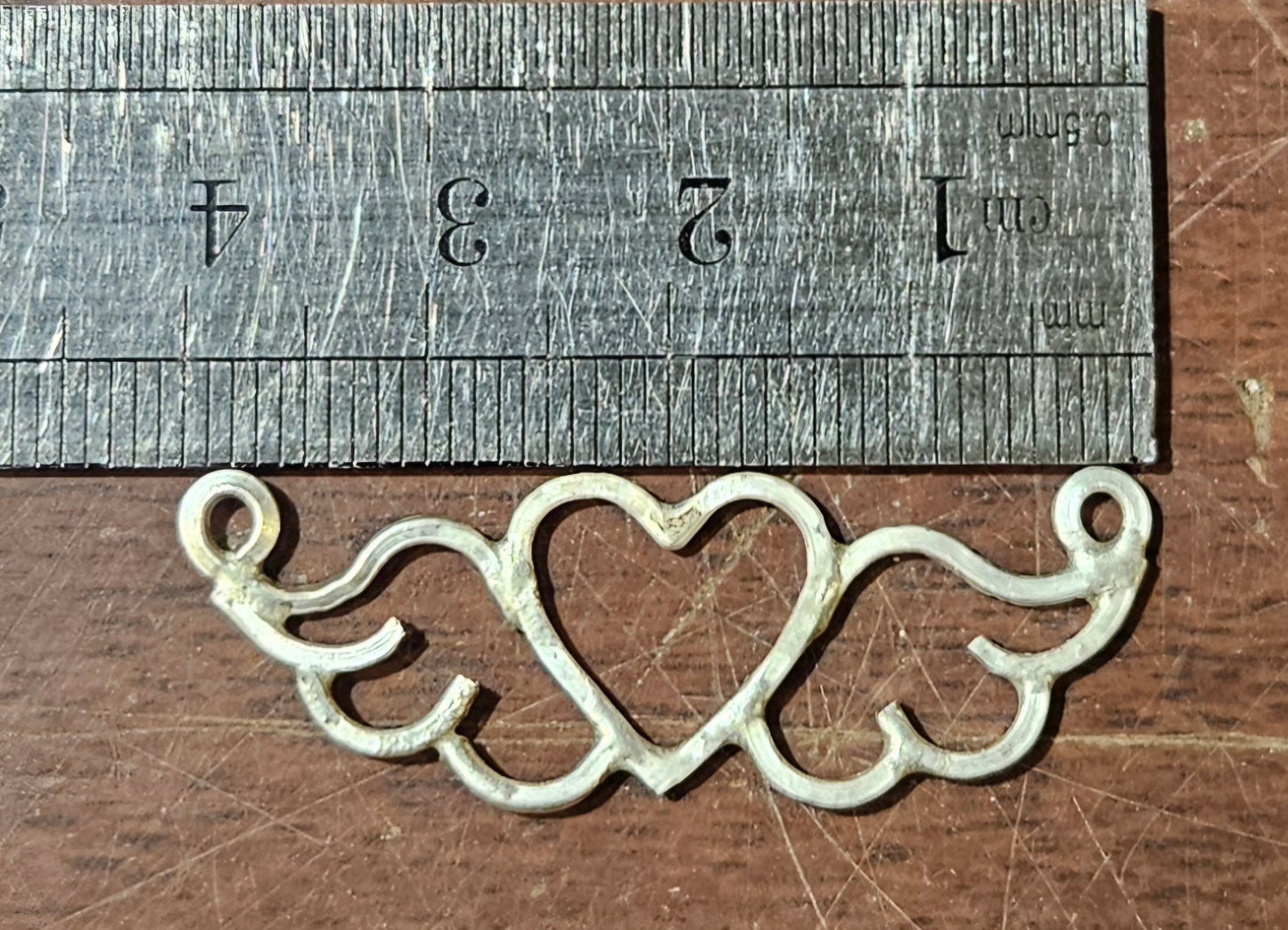 Small (40mm wide) Heart-Wing pendant in solid sterling silver and a solid sterling silver fine chain with ruler, showing size.