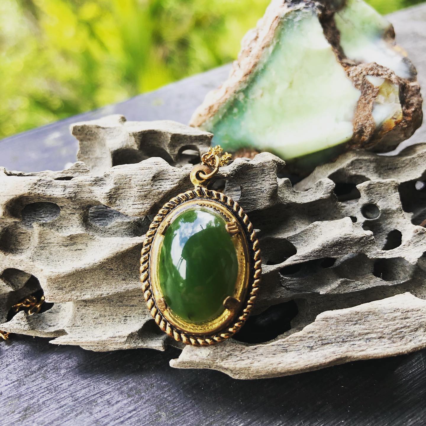 Necklace with bright green New Zealand Pounamu (nephrite jade) hand polished to an 18x13mm cabochon with a bright, glassy polish, and set in a gold plated setting with 19 inch chain, front on.