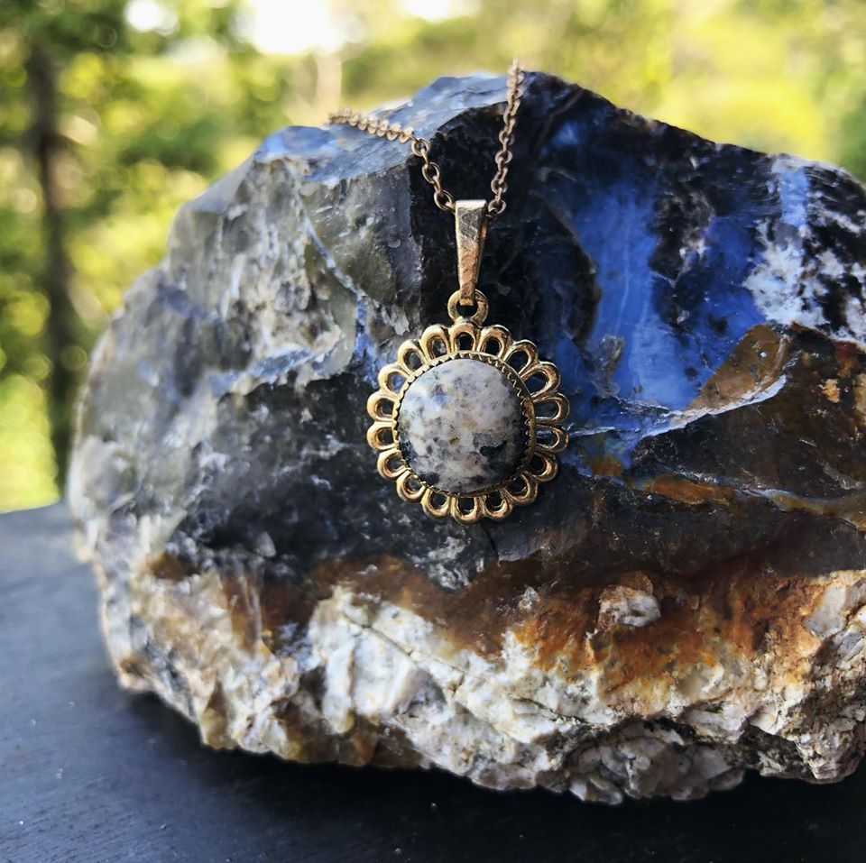 Necklace with granite from Scottland, pink with black spots, hand polished to a 10mm round cabochon and set in a gold plated setting with 19 inch chain.