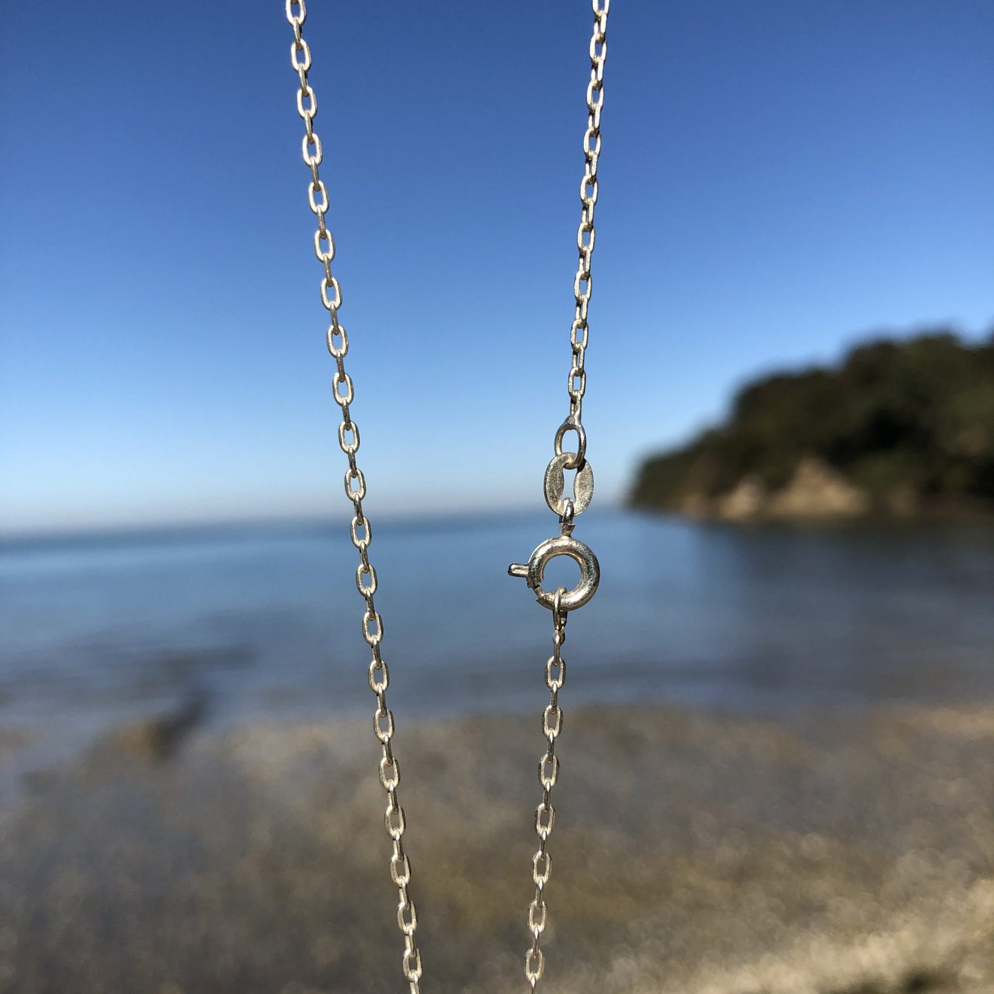 Necklace with large carnelian from Coromandel New Zealand with deep translucent orange color and side swirls of yellow/tan, hand polished to a 40x30mm cabochon and set in silver plated setting with 19 inch chain - chain clasp