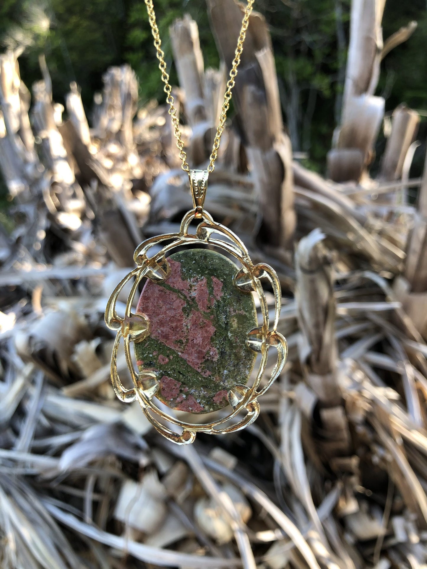Necklace of green and pink unakite from South Island New Zealand, hand polished into a 40x30mm cabochon and set in gold plated setting with 19 inch chain. Unakite was descried as only found in Virginia USA for years until this deposit was discovered in New Zealand. This stone combines both the pink and green colours of the heart chakrah, from back
