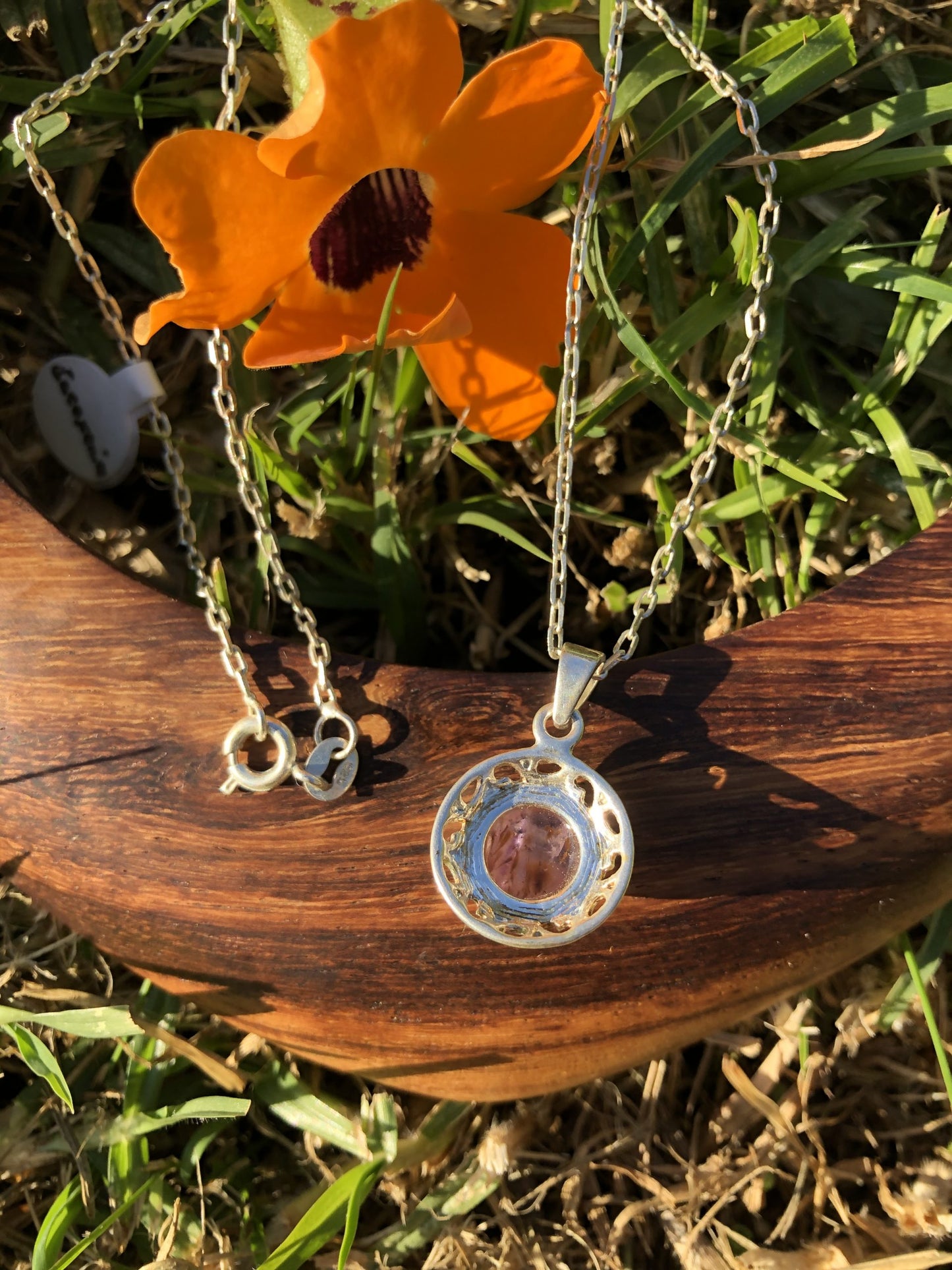 Necklace with natural Super-7, a purple amethyst with golden needles of cacoxenite, hand polished to a 10mm round cabochon and set in silver-plated setting with 19 inch chain, back