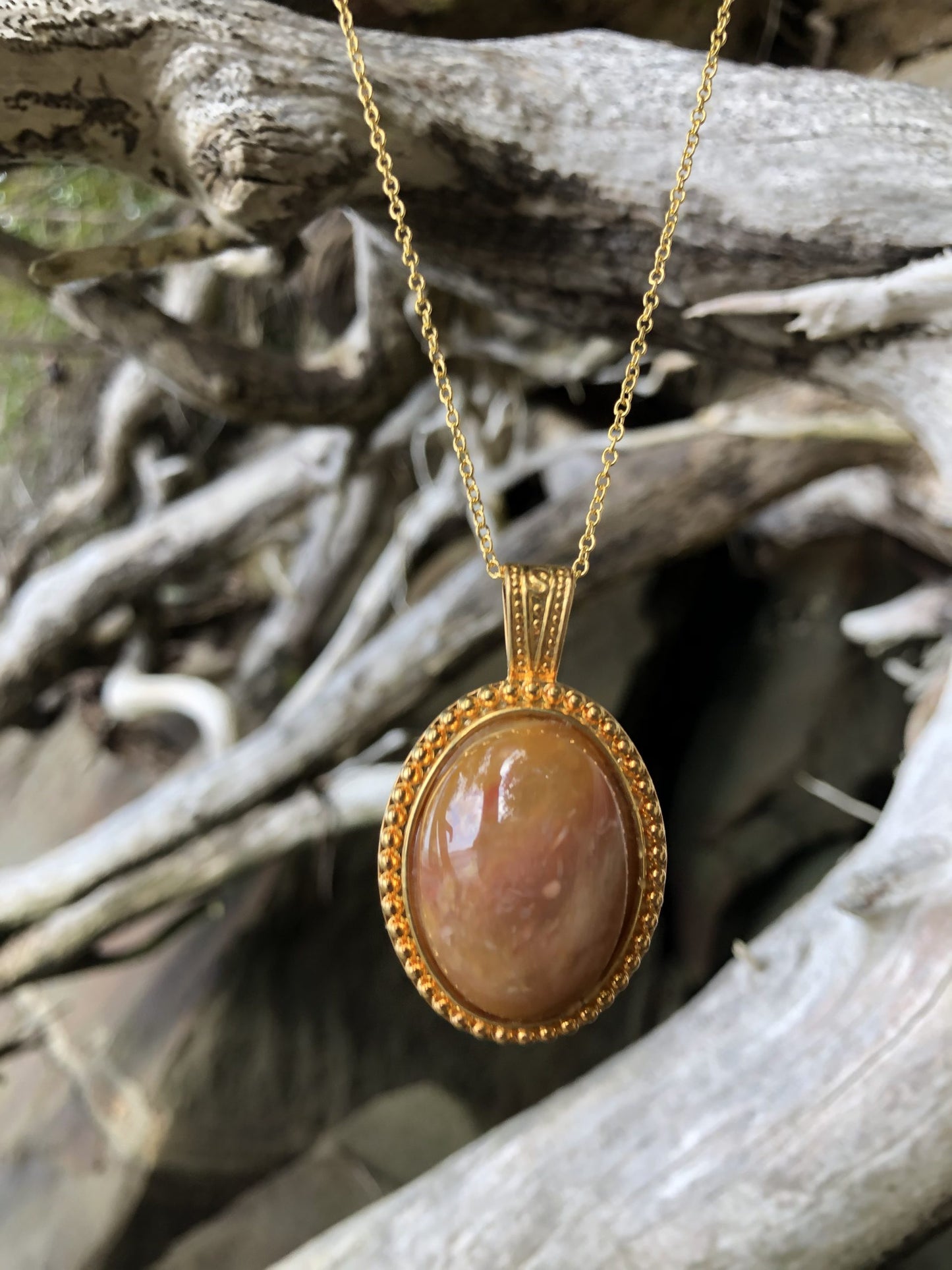 Necklace with a beautiful honey chert from Coromandel New Zealand with swirls of yellow and white. This stone is hand polished in a 30x22mm cabochon and set in a gold-plated setting with a 19 inch chain, on driftwood