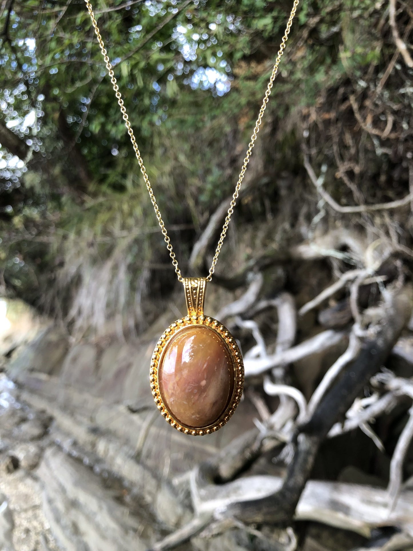 Necklace with a beautiful honey chert from Coromandel New Zealand with swirls of yellow and white. This stone is hand polished in a 30x22mm cabochon and set in a gold-plated setting with a 19 inch chain on beachcliff