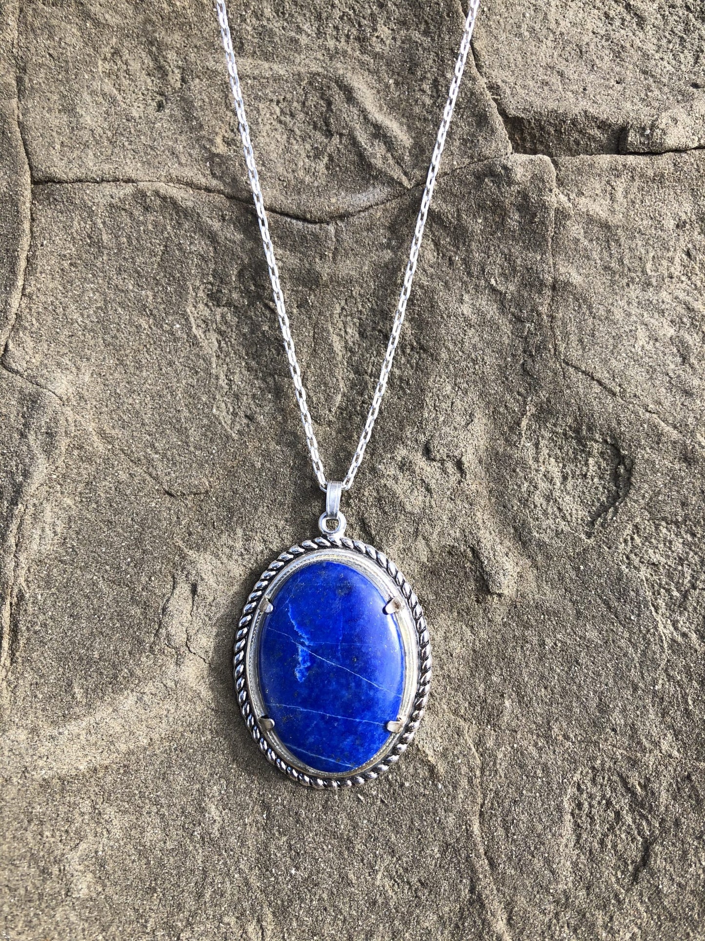 Necklace with rich blue lapis lazuli, hand cut to a 30x20mm cabochon and set in silver plated setting with 19 inch chain.