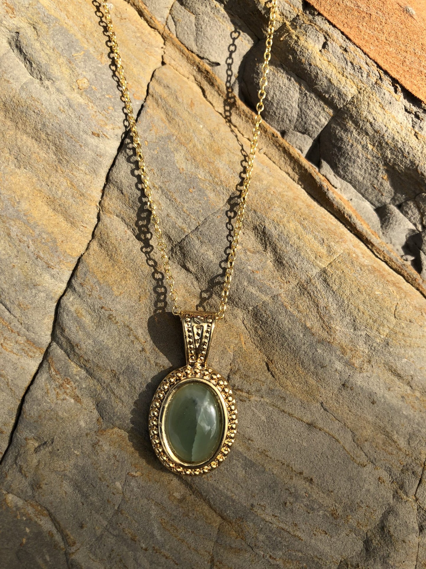 Necklace with Botswana Jade (green aventurine), hand polished to a 14x10mm cabochon and set in a gold-plated setting with 19 inch chain, on rock