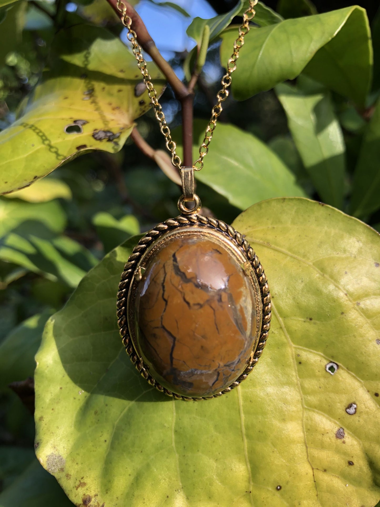 Necklace with storm agate from Northlands New Zealand with yellow-brown jasper breccia in a matrix of grey chalcedony agate, hand cut to a 30x22mm cabochon and set in a gold-plated setting with 19 inch chain.