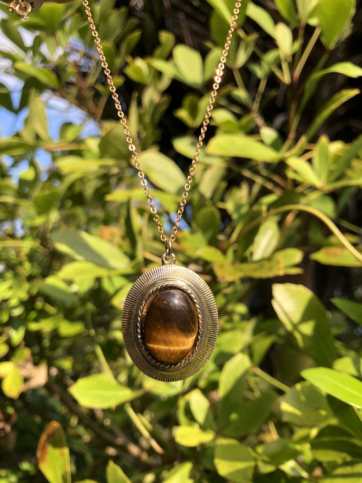 Necklace with golden yellow Tiger's Eye, hand polished to a 20x15mm cabochon and set in a gold-plated setting with 19 inch chain on bush