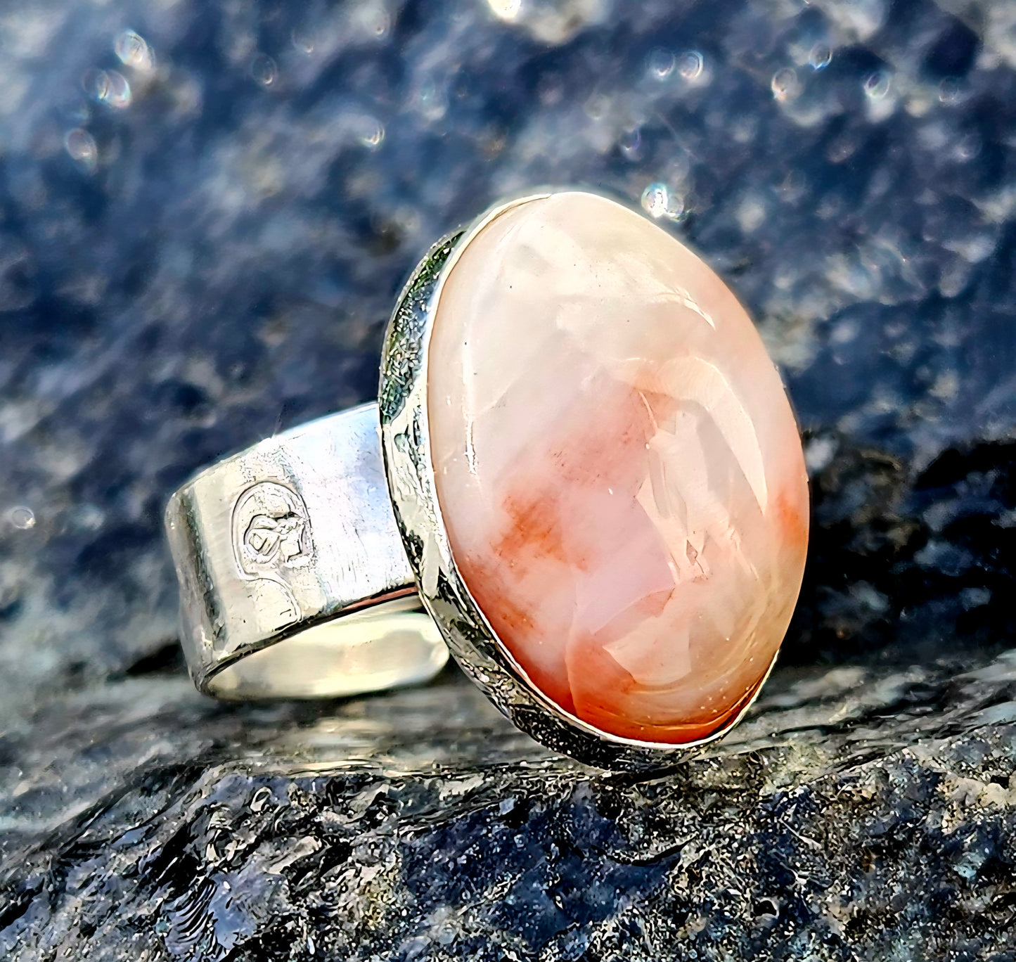A strong and subtle New Zealand petrified wood, hand cut and polished to an 18x13mm cabochon and set in a sterling silver, adjustable ring, angle.