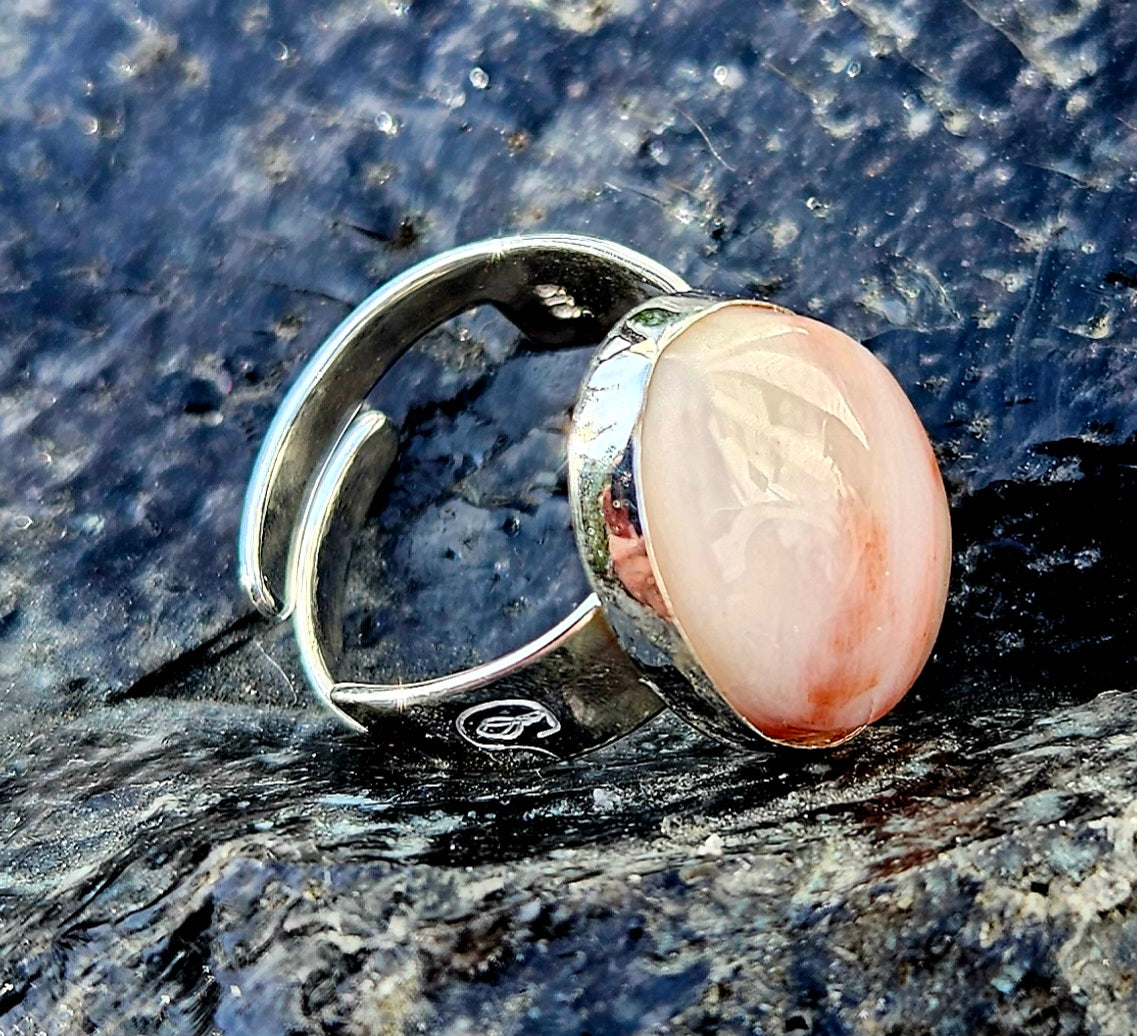 A strong and subtle New Zealand petrified wood, hand cut and polished to an 18x13mm cabochon and set in a sterling silver, adjustable ring, side.