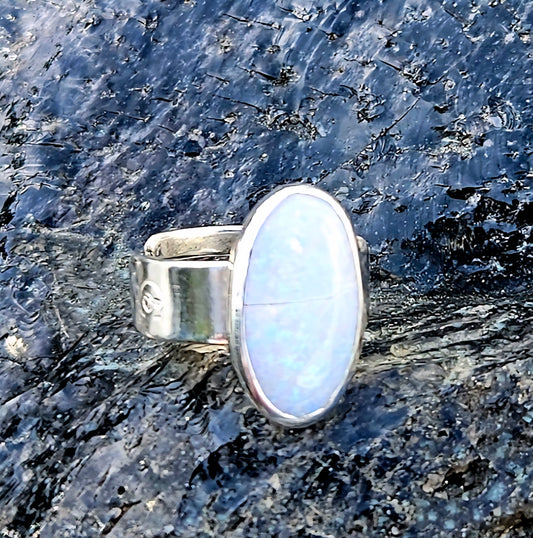 A beautiful 2.7ct Australian opal with lots of fire, hand cut and polished and set in a sterling silver, adjustable ring, front.