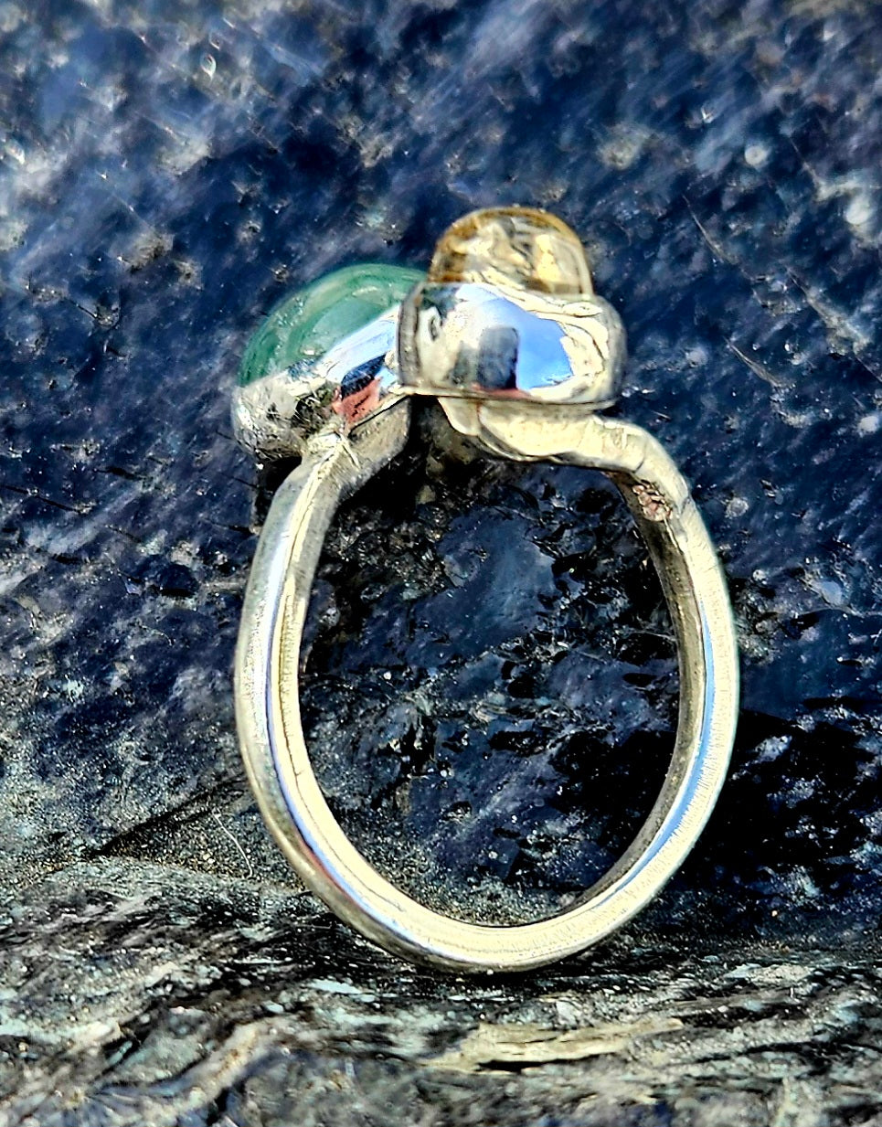 A green mtorolite from Zimbabwe with a yellow citrine from Brazil, hand polished and set in a sterling silver, bypass ring, side.