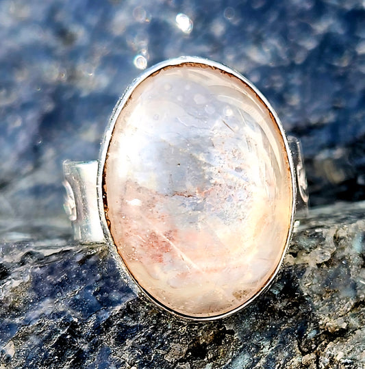 A sparkling clear quartz, hand cut and polished to a 18x13mm cabochon and set in a sterling silver, adjustable ring, top.