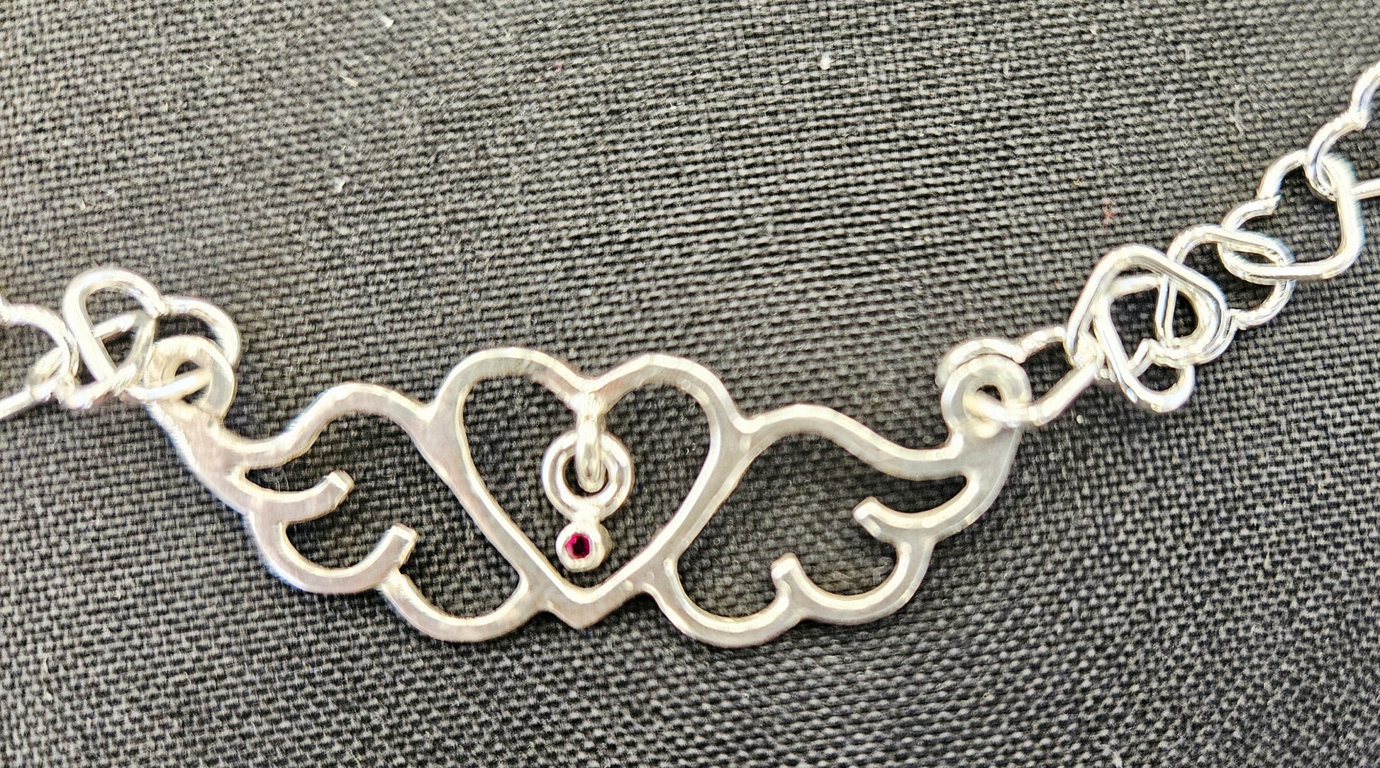 Small (40mm wide) Heart-Wing pendant with a ruby charm, all in solid sterling silver and a solid sterling silver heart chain, closeup of Heart-Wing.