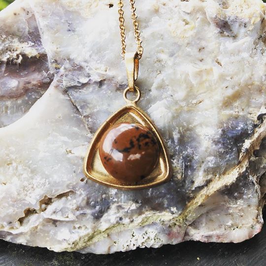 Necklace with New Zealand Mahagony obsidian, brown with black spots, hand polished to a 14mm round cabochon and set in a triangular gold plated setting with 19 inch chain, on Quartz