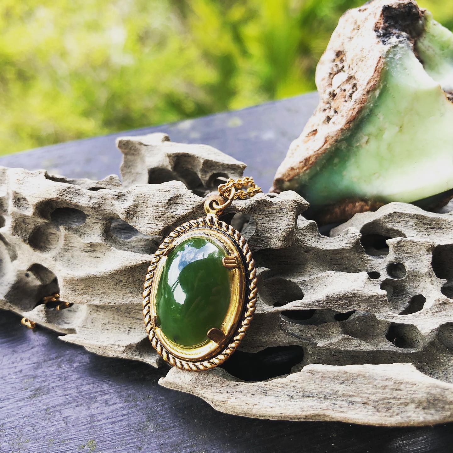 Necklace with bright green New Zealand Pounamu (nephrite jade) hand polished to an 18x13mm cabochon with a bright, glassy polish, and set in a gold plated setting with 19 inch chain, angled