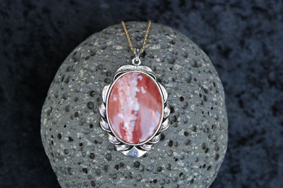 Neclace with Jasper from the Fourth Branch of the Tairua River in Coromandel New Zealand with rich red jasper and a thick vein of blue chalcedony running up the middle. Hand cut into a 40x30mm cabochon and set in a silver plated setting with 19 inch chain on black scoria
