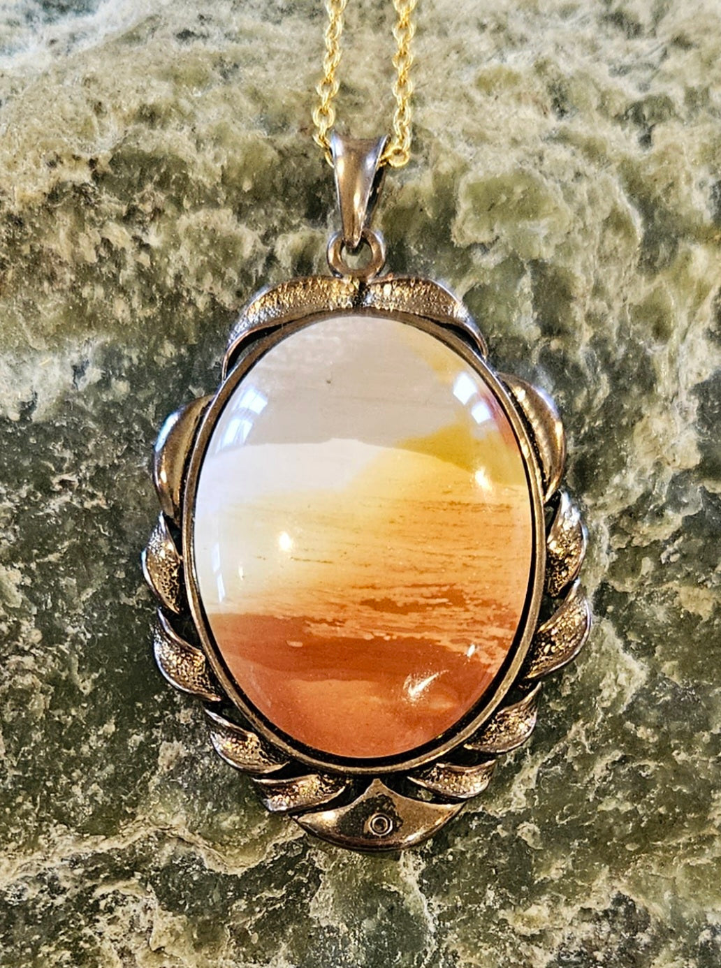 Necklace of Mookaite from Western Australia. The layering of colors from red, orange, yellow, white and tan create a scene like a sunset on the beach. I spent some time orienting the rough stone in the saw to get this arrangement of colors and hand polished this stone to a 40x30mm cabochon, set in gold plated setting with 19 inch chain.