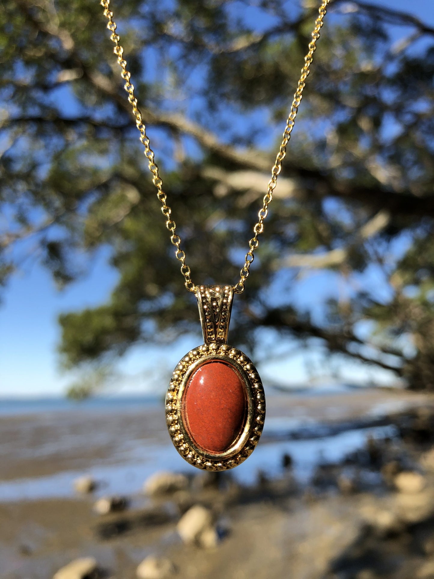 Necklace with New Zealand red Jasper, pure bright red, hand polished to a 14x10mm cabochon and set in a gold plated setting with 19 inch chain.