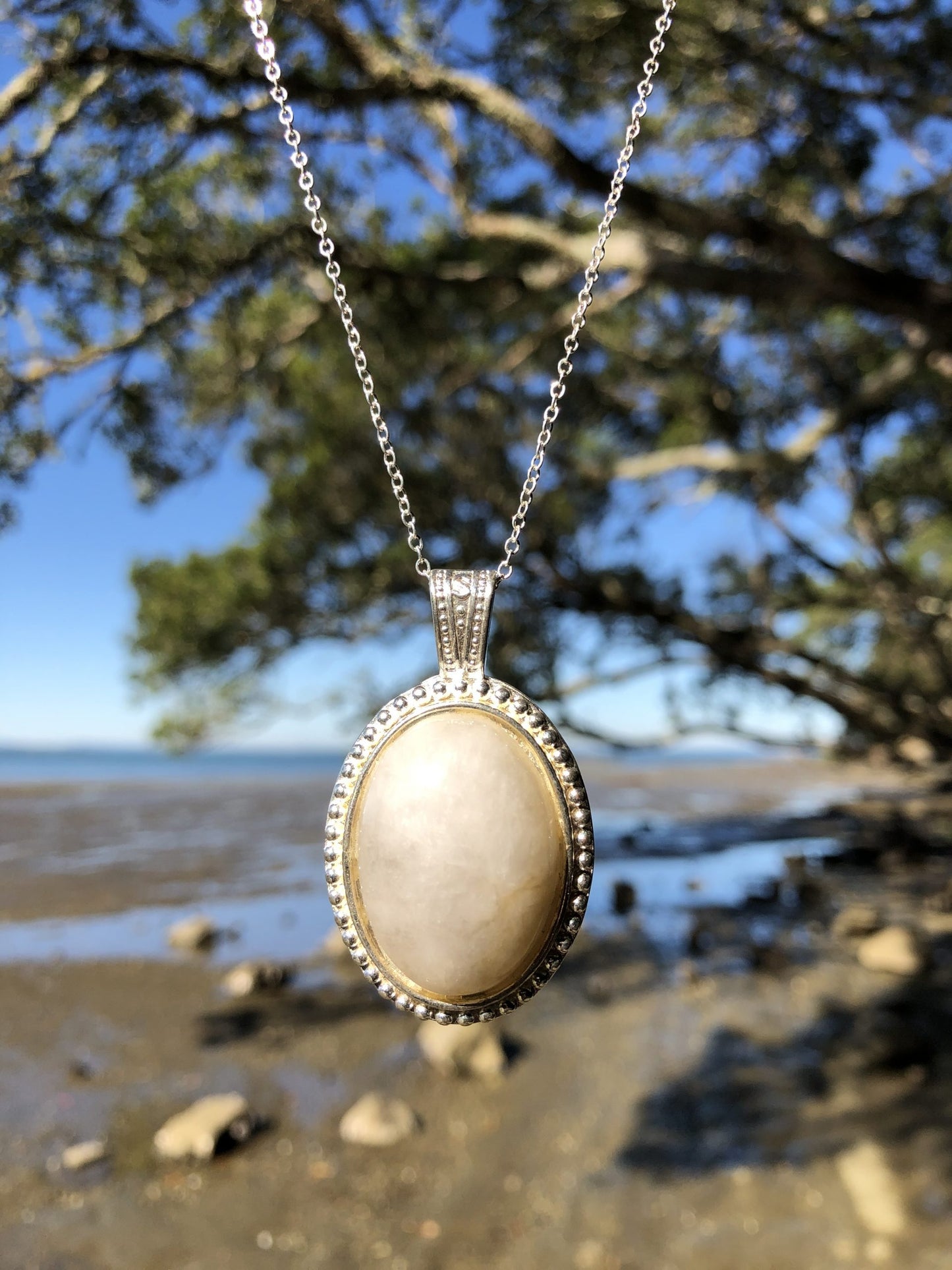 Necklace with a beautiful honey chert from Coromandel New Zealand with subtle swirls of yellow on white. This stone is hand polished in a 30x22mm cabochon and set in a silver plated setting with a 19 inch chain, darker