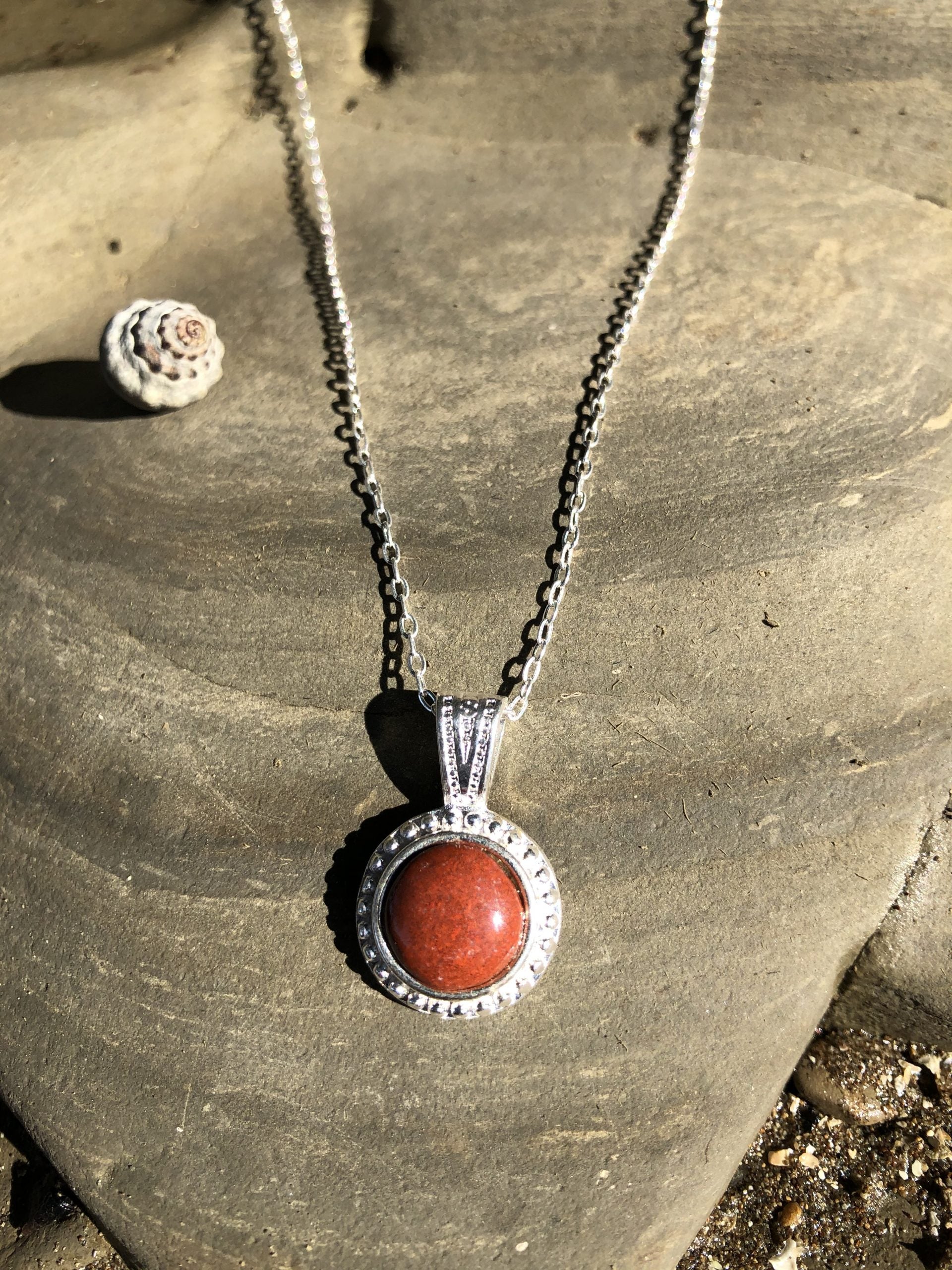 Necklace with New Zealand red Jasper, rich, brilliant red, hand polished to a 10mm round cabochon and set in a silver plated setting with 19 inch chain.