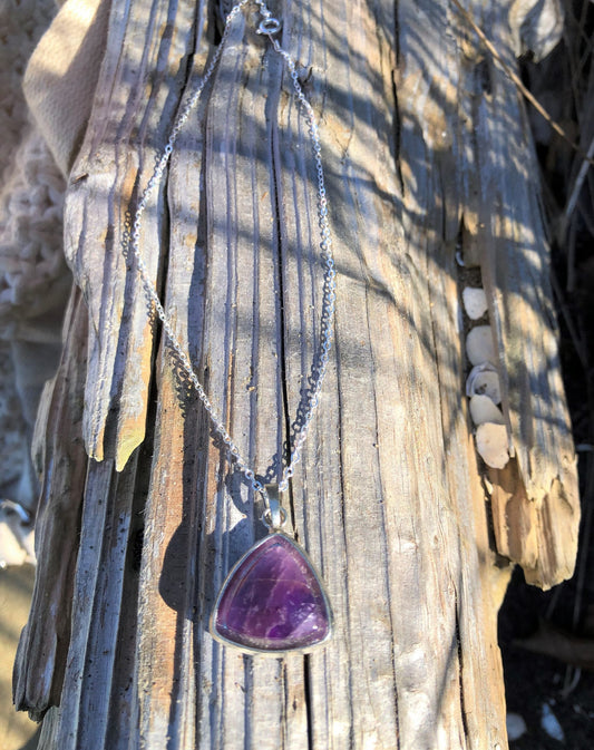 Necklace with rich, dark purple Amethyst, hand polished to a 18x18x18mm triangular cushion cabochon and set in a silver-plated setting with 19 inch chain on driftwood