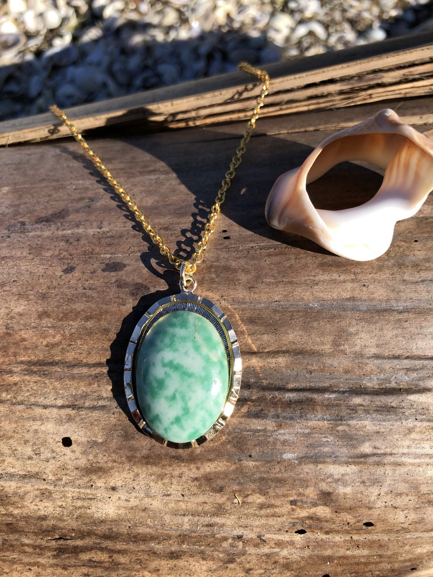 Necklace with an unusual mix of green jade in white quartz, found on a beach in California, USA and hand polished to a 25x18mm cabochon and set in a gold plated setting with 19 inch chain, on stone