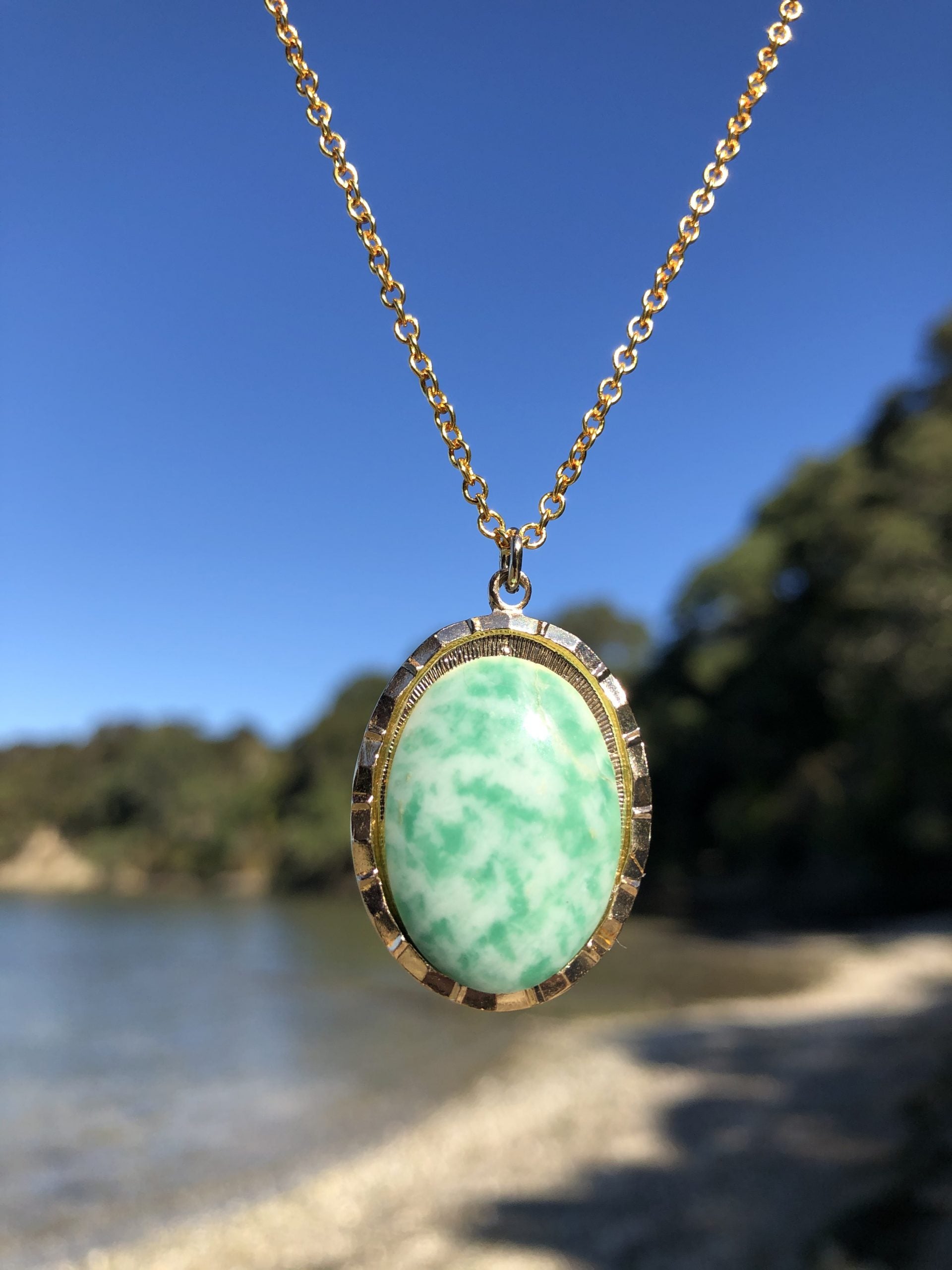 Necklace with an unusual mix of green jade in white quartz, found on a beach in California, USA and hand polished to a 25x18mm cabochon and set in a gold plated setting with 19 inch chain, on beach