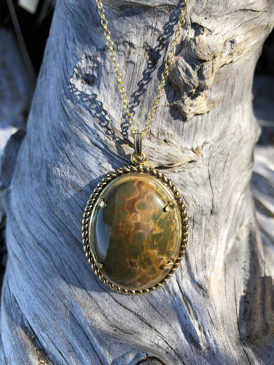 Necklace with Polagonite Jasper collected from Canterbury, South Island New Zealand by a friend of mine and hand polished into a 30x22mm cabochon, set in a gold plated setting with 19 inch chain. This stone shows both the characteristic pattern of this stone of green and yellow dots, front