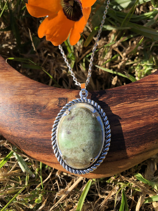 Necklace with an earthy green New Zealand Pounamu (nephrite jade), hand polished to a 25x18mm cabochon and set in a silver-plated setting with a 19 inch chain, front