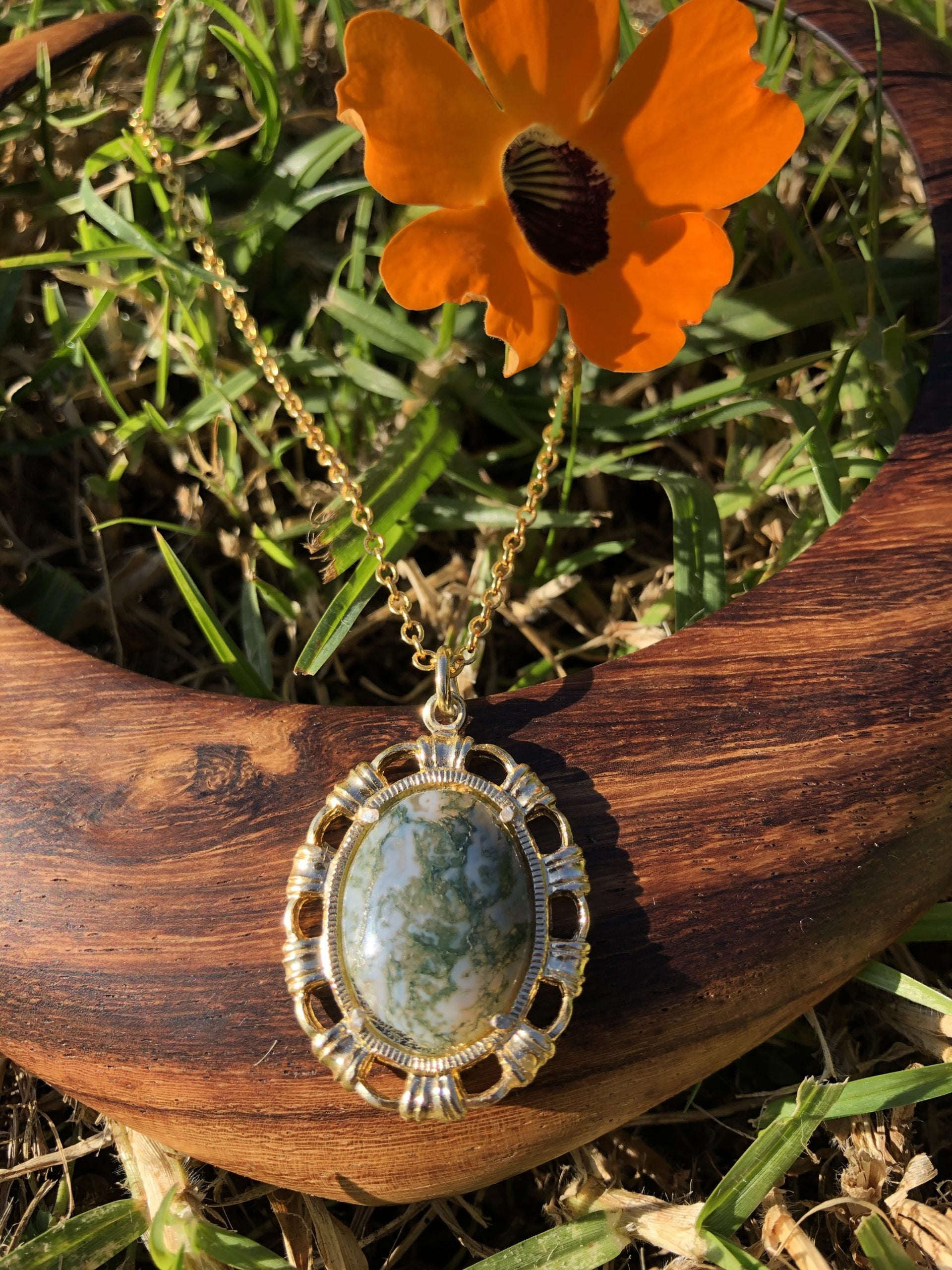 Necklace with natural Moss Agate from India, showing finely grained dark green "moss" in a transluscent milky white background, hand polished to a 20x15mm cabochon and set in gold plated setting with 19 inch chain.