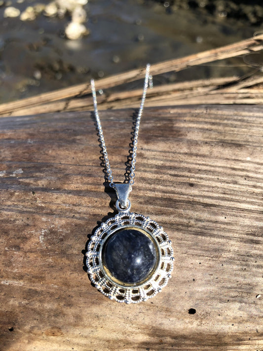 Necklace with natural dark blue sodalite, hand polished to a 14mm round cabochon and set in a silver plated setting with 19 inch chain.