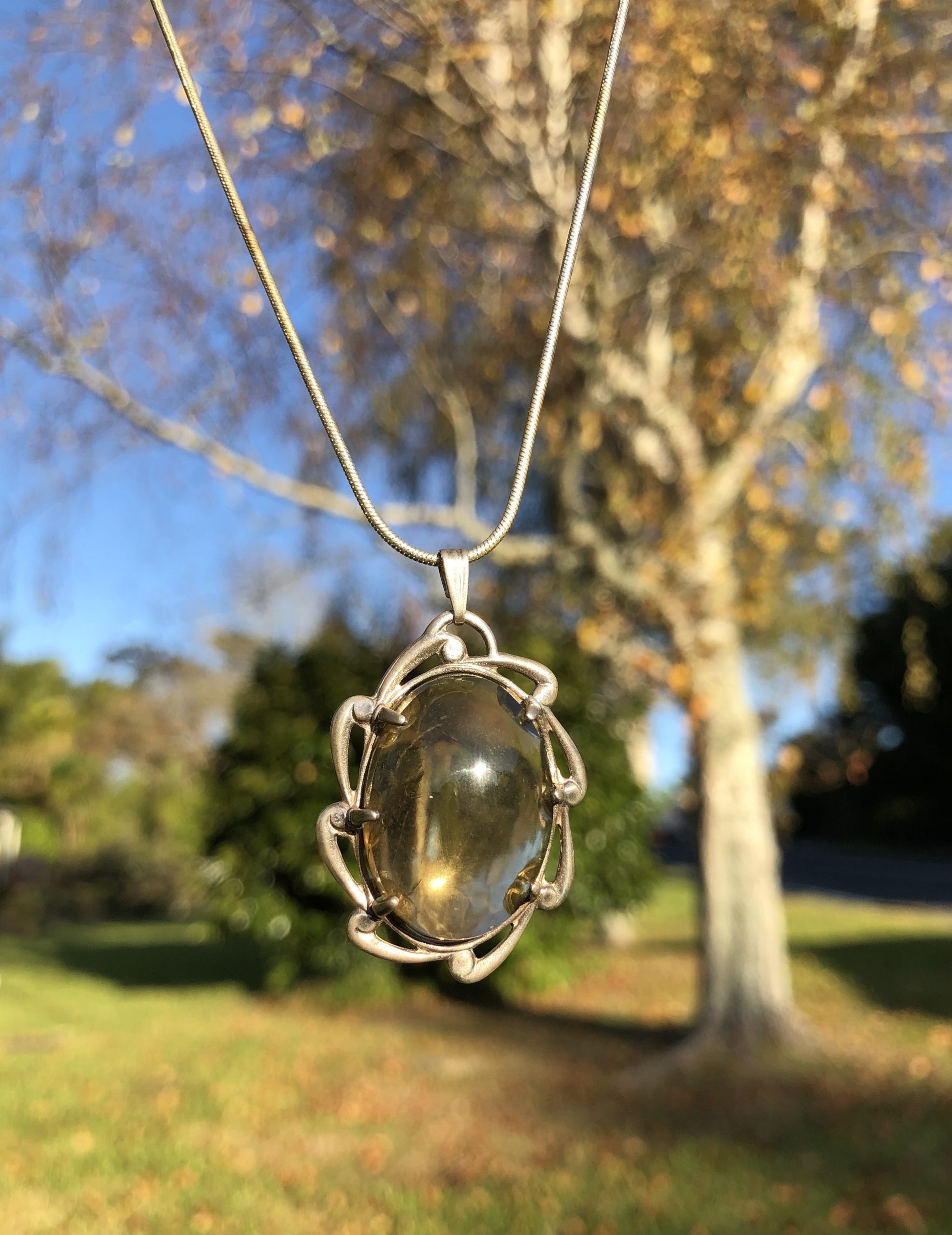 Necklace with a natural Brazilian Citrine, clear smokey yellow with, hand polished to an 25x18mm cabochon and set in a Sterling silver setting with 24 inch Sterling silver snake chain, front