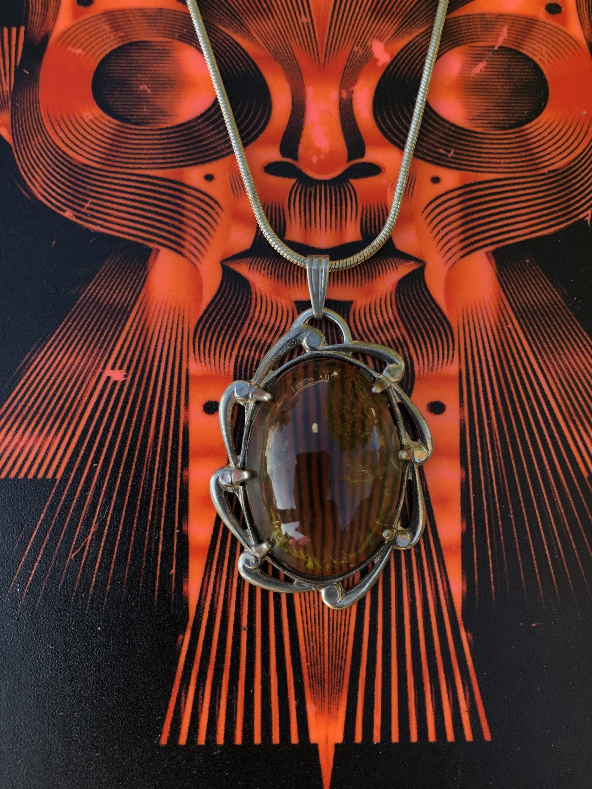 Necklace with a natural Brazilian Citrine, clear smokey yellow with, hand polished to an 25x18mm cabochon and set in a Sterling silver setting with 24 inch Sterling silver snake chain on sculpture