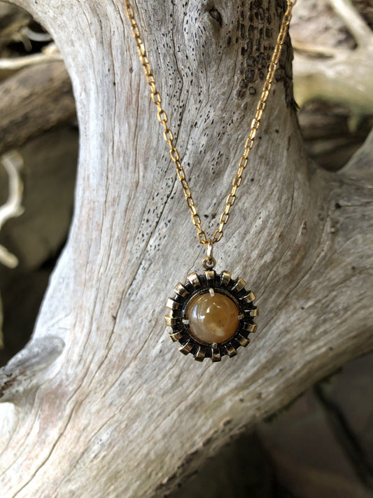 Necklace with a beautiful honey chert from Coromandel New Zealand with swirls of yellow and white. This stone is hand polished in a 10mm round cabochon and set in a gold-plated setting with a 19 inch chain.