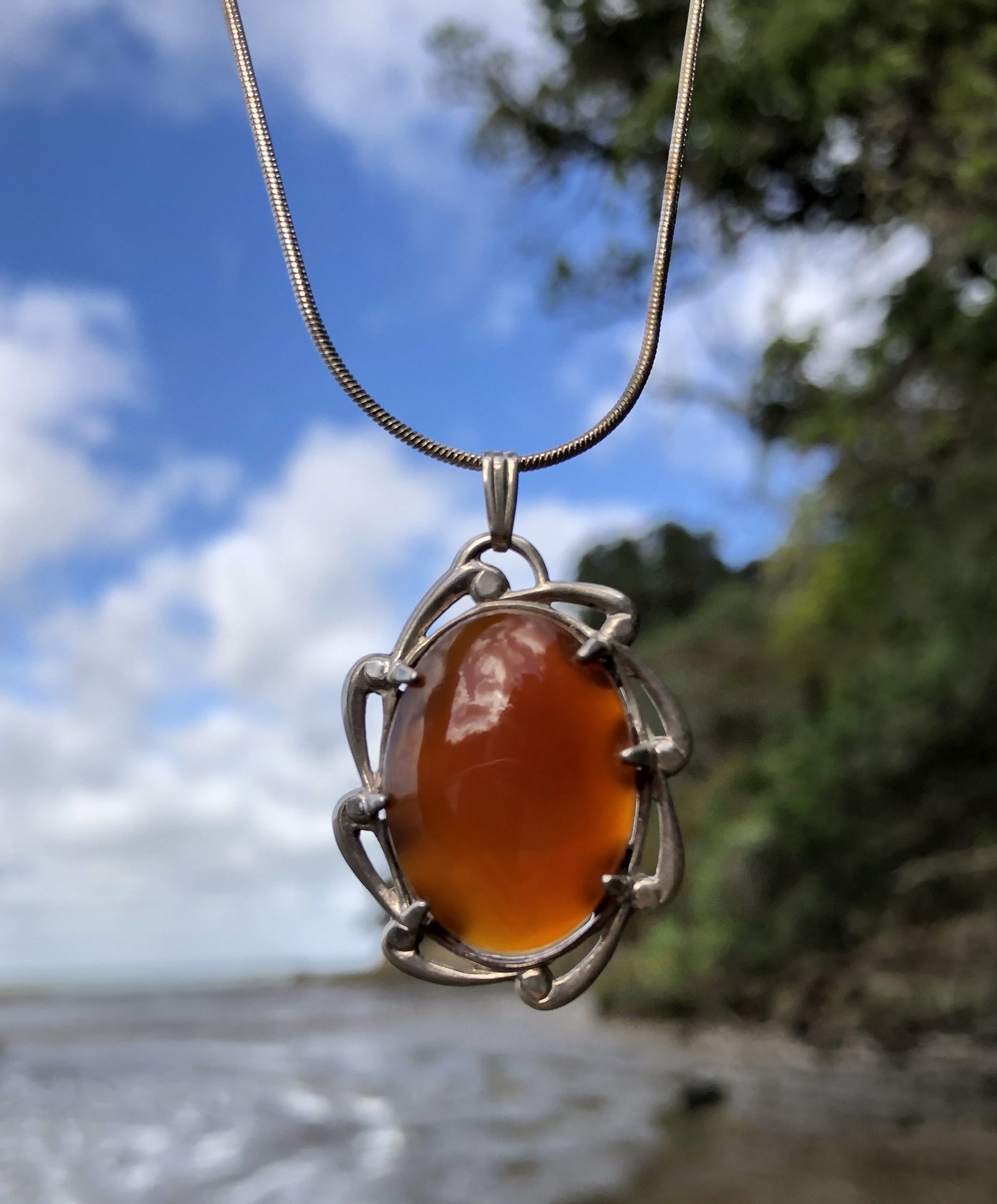 Necklace with a flawless caramel orange New Zealand Carnelian, hand polished to a 25x18mm cabochon and set in a sterling silver setting with a 20 inch sterling silver snake chain, front