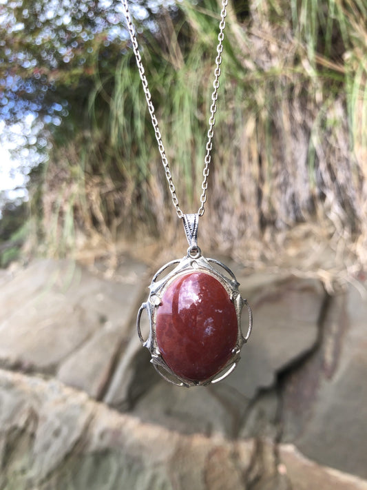 Necklace with Red Jasper, from Coromandel, New Zealand, bright red with some white markings, hand polished to a 30x22mm cabochon and set in a silver plated setting with 19 inch chain.