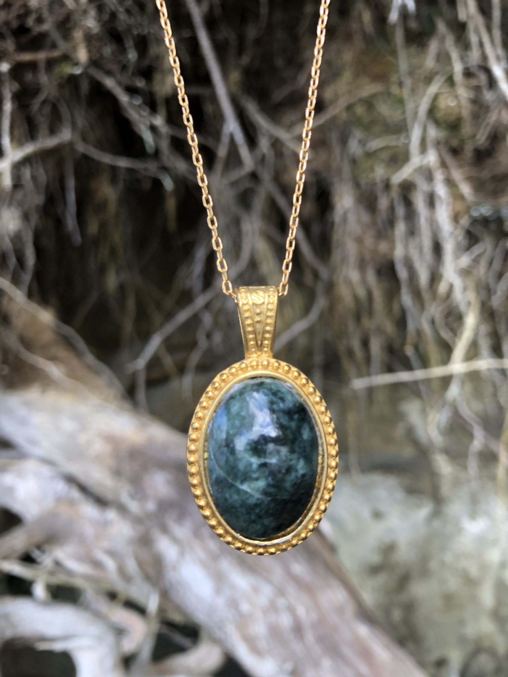 Necklace with natural New Zealand serpentine, dark green with subtle markings, hand polished to a 25x18mm cabochon and set in a gold-plated setting with 19 inch chain on driftwood