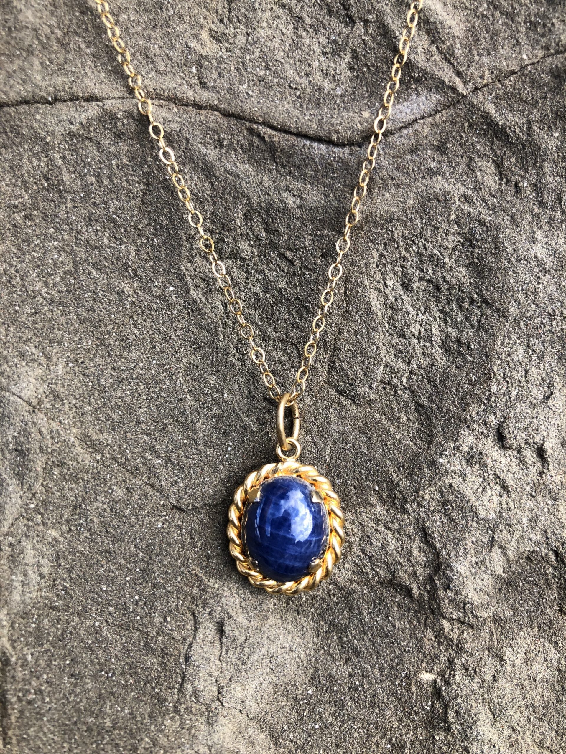 Necklace with a rich blue sapphire, hand polished to a 12x9mm cabochon and set in 14 carat gold filled setting with an 18 inch, 14 carat gold filled chain, front