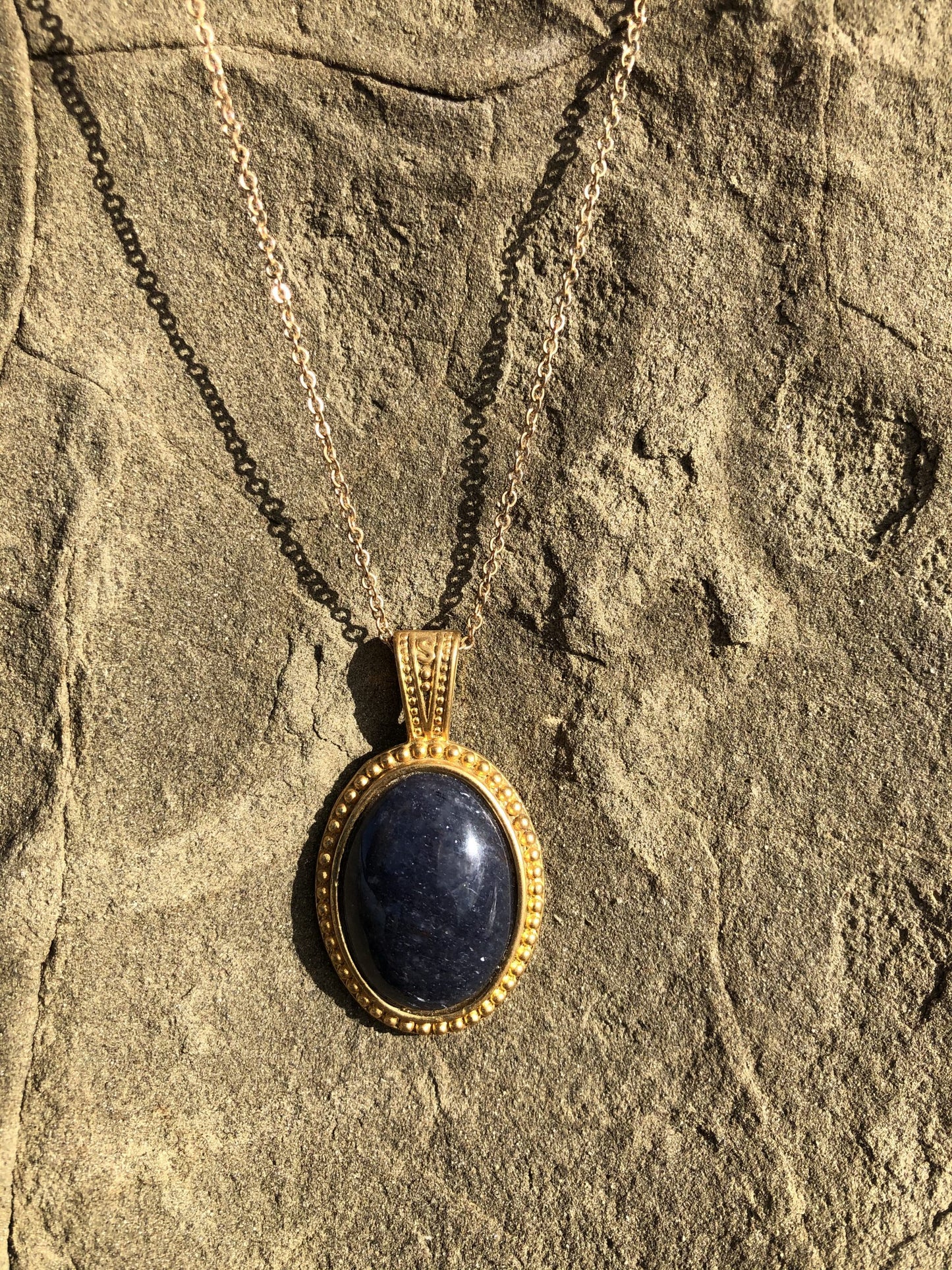 Necklace with natural blue aventurine, hand polished to a 25x18mm cabochon and set in a gold plated setting with 19 inch chain, on rock
